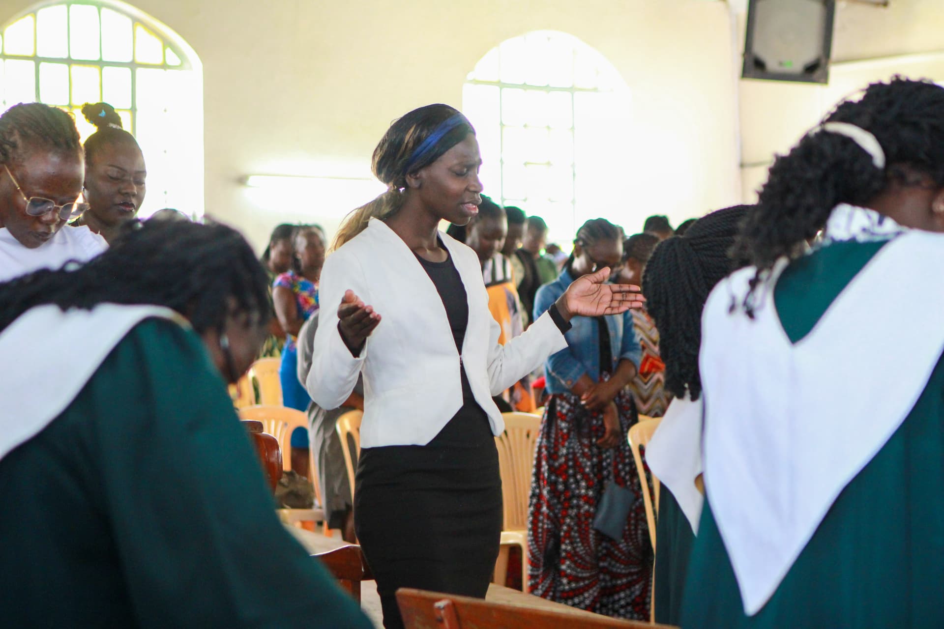 A young woman of G.S.Y leading the congregation in prayer during the church service